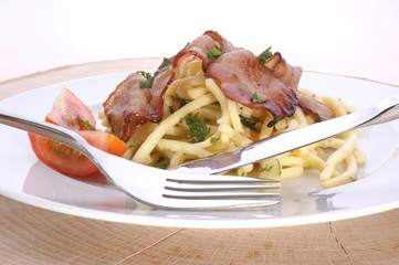 Pasta with tomato and bacon on a plate