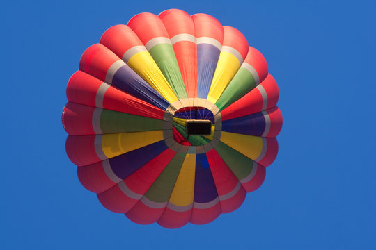 bunt gestreifter fliegender Hei&szlig;luftballon, ganze Ansicht mit Korb von unten