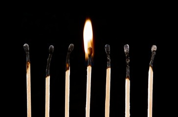Burning match on a black