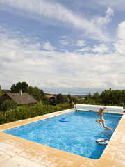 enfant sautant dans la piscine