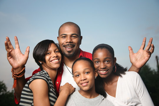 Happy African American family, father with teenage daughters.