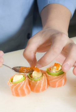 Sushi Chef preparing salmon roll