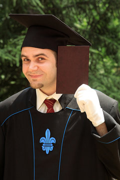 Male Graduate Holding Diploma Proudly Outdoor