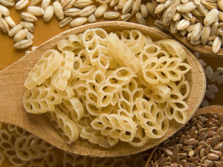 Wooden spoon with macaroni. Shallow DOF.