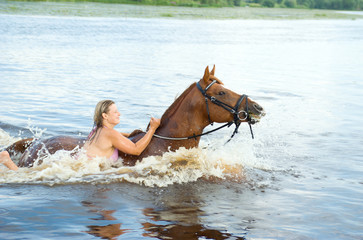 woman swimming winth  stallion in river
