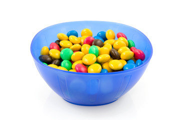 blue plastic bowl with chocolate candy on white background