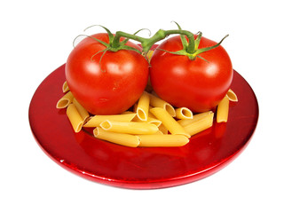 tomatoes with uncooked pasta served on red plate