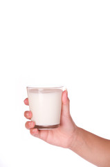 A hand holding a glass of milk