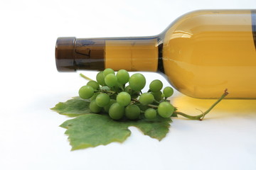 Bottle of white wine, grapes and grape leaf