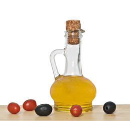 Bottle of olive oil, tomatoes, and olive fruits on table