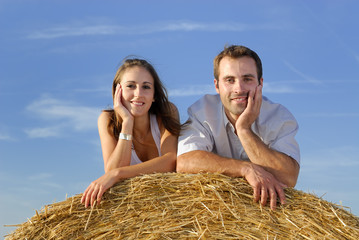 jeune couple couché sur un ballot de paille