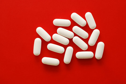 white pills over red background