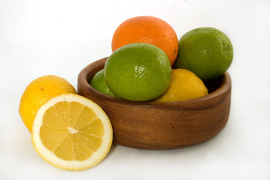 Lemons, Limes And Oranges In A Wooden Plate