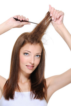 young brunette girl doing backcombing with comb