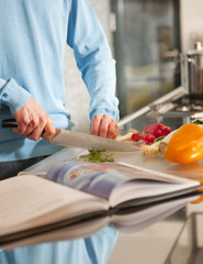 Obraz na płótnie Canvas Man's hands cutting vegetables for a meal