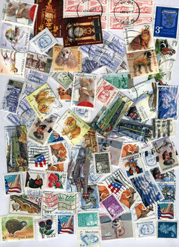 heap of different vintage post stamps, paper texture background closeup, hobby collection diversity © FMUA