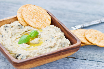 Hummus dip with olive oil and basil leaves.
