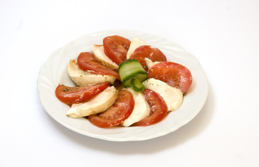 Cheese, tomato and cucumber on white plate