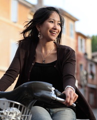 Young woman on a bike, smiling while outdoors.