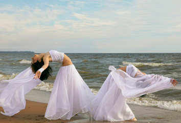 Fototapeta na wymiar Two white angels on the beach