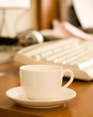 Closeup of coffee cup near keyboard