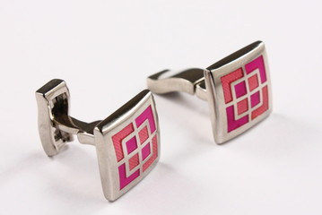 a pair of pink cuff links