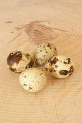 Fototapeta premium four organic quail eggs on a timber board