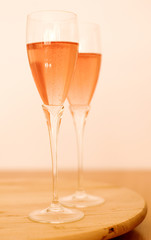 Two glasses of rose champagne on wooden table