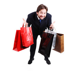 Young attractive man wearing suit and holding shopping bags