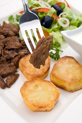 Grilled meat with baked potatoes and vegetable salad