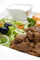 Grilled meat with baked potatoes and vegetable salad