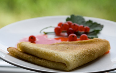 Pancakes with red currant jam on dish