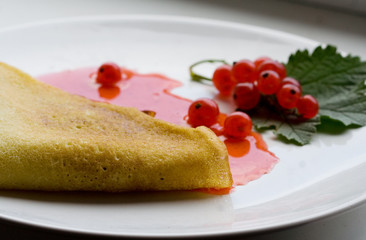 Pancakes with red currant jam on dish
