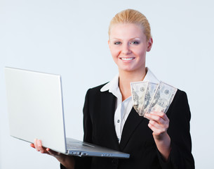 woman holding dollars and a laptop