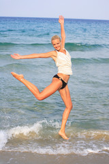 tanned blond woman in bikini in the sea
