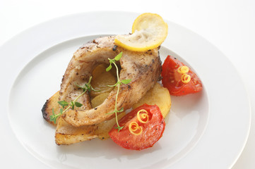carp steak with potato and tomato on a plate