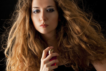 Fototapeta premium attractive blond woman applying perfume on her body