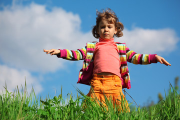 little girl on grass against sky