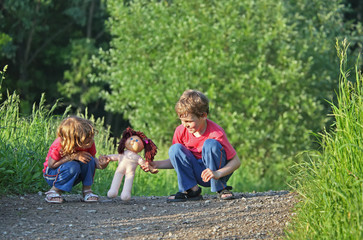 Children with doll on path in park