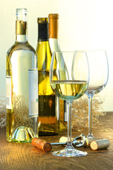 Bottles of white wine with glasses