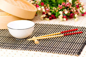 Chopsticks and bowl on the bamboo mat