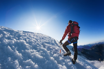 Bergbeklimmer bereikt de top van een hoge bergtop.