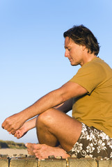 Naklejka na ściany i meble mature man sitting cross legged and meditating.