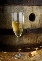 Glass of white wine on background of wine barrel