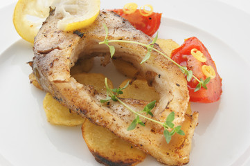 grilled carp fillet on organic potato with lemon