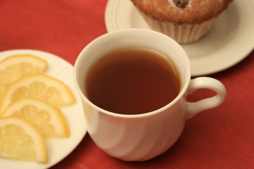 A cup of tea with leamon and a cup cake
