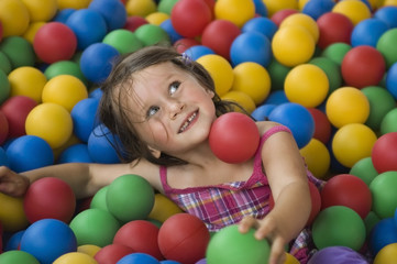 Little girl having fun time in balls pool