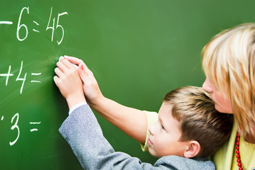 Teacher and little boy at blackboard