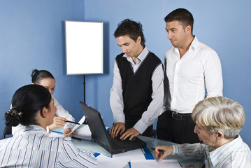 Business people using laptop in office