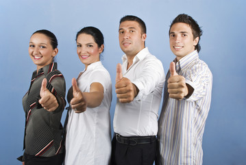 Young business team giving thumbs up